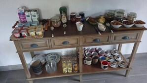 Ein Holztisch mit verschiedenen Küchenutensilien, darunter Gläser, Tassen und Teller.