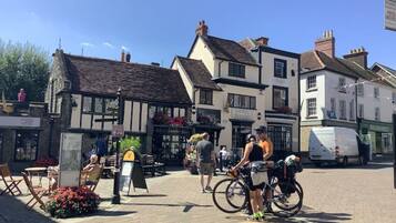 A traditional European town square with historic buildings, outdoor seating, and bicycles.