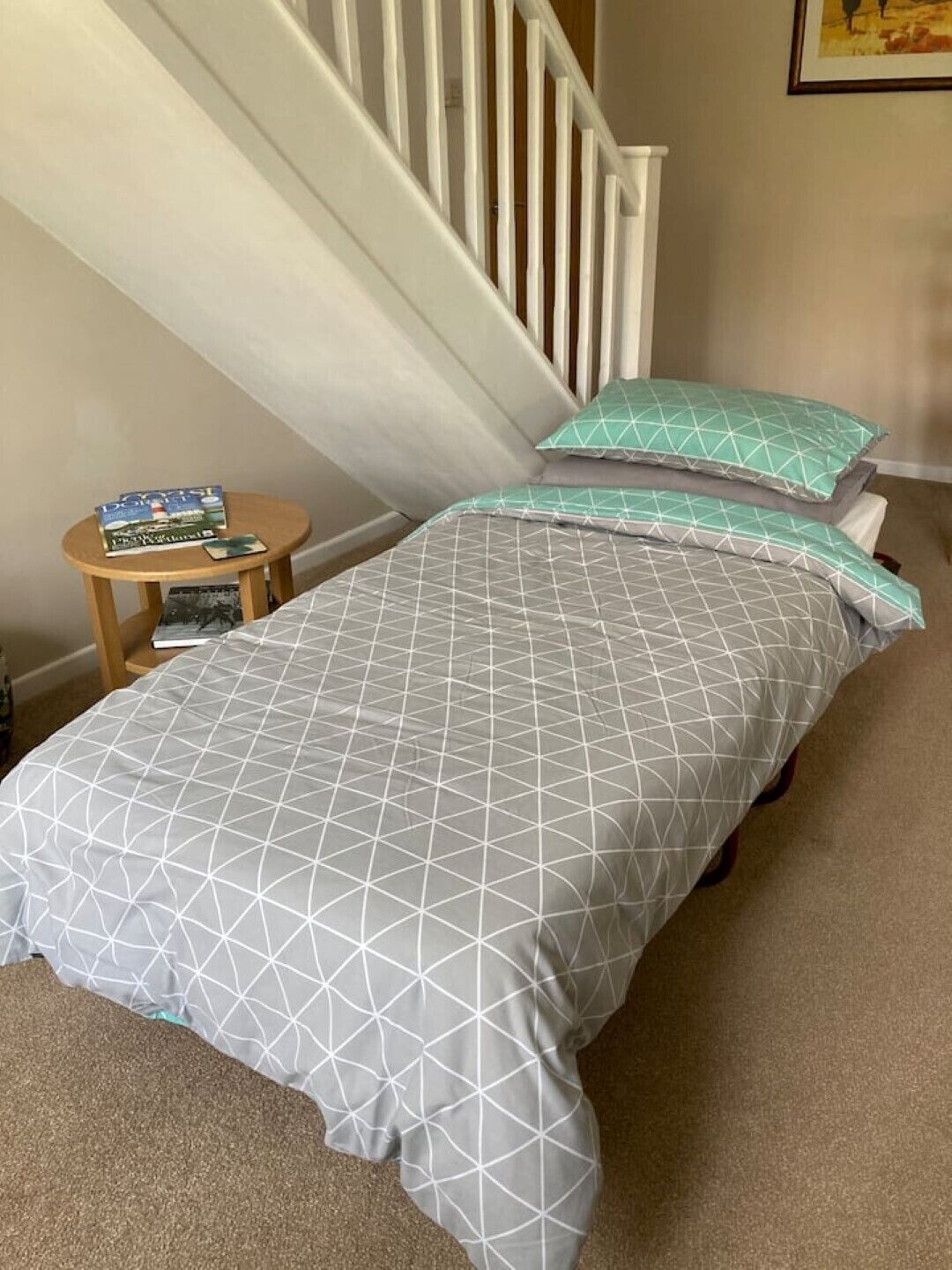 Un dormitorio con cama, mesita de noche y escalera.
