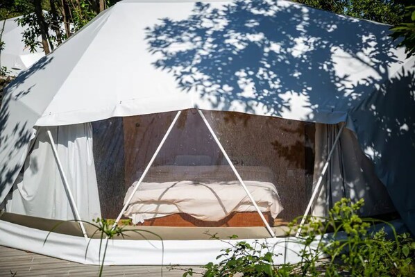 A dome-shaped tent with a bed inside, surrounded by trees. - Domes Horta (Angra do Heroísmo)