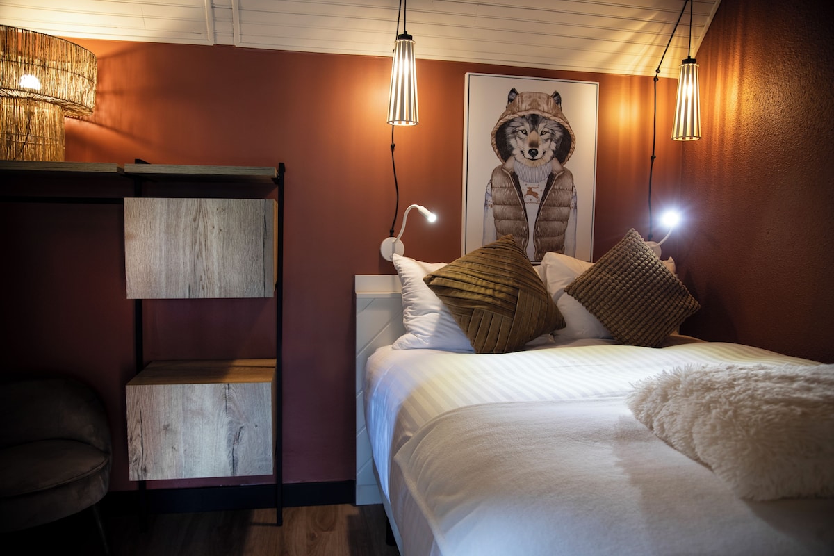 A bedroom with a bunk bed, a wooden shelf, a fluffy white throw, and a poster of a wolf.