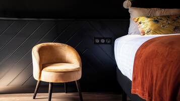 A modern room with a bed, a chair, and a wall with a geometric pattern.