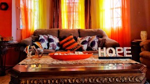 A cozy living room with a sofa, decorative pillows, a coffee table, and a bowl of snacks. - 2 Bed-sleeps 4-gated Community-5 Min Town Centre (Falmouth)