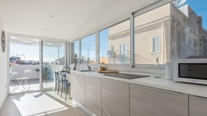 Una cucina moderna con ampie finestre, un'area pranzo e vista sugli edifici.