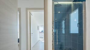 Un bagno moderno con box doccia in vetro e WC a vista.