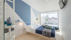 Una camera da letto moderna con un letto, una scrivania e un balcone.