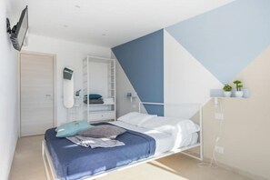 Et soveværelse med køjeseng, garderobeskab, skrivebord og en lille hylde med planter.