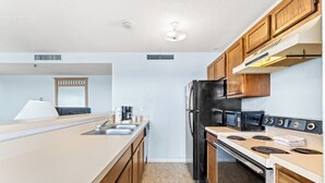 A modern kitchen with a central island, stainless steel appliances, and wooden cabinetry. - MB Renaissance 1516- 2BR/2BA Oceanfront Condo in Myrtle Beach (Myrtle Beach)
