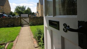 A white door with a black handle and a mailbox. - Noel Cottage (Chipping Campden)