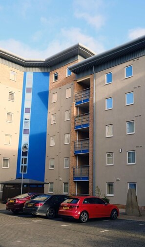 Stylish residential building with ground-floor balconies and parking area.