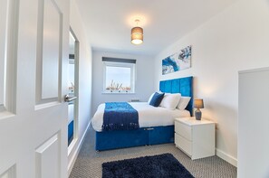 Relax in a serene bedroom with a large bed, nightstands, and a city view.