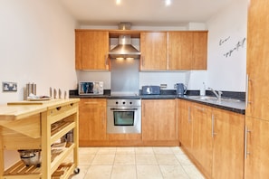 Enjoy cooking in this well-equipped kitchen with oven, range hood, and ample workspace.