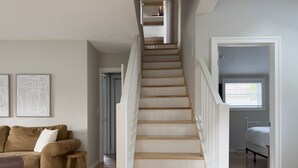 A staircase with wooden steps and white railings leading to a bedroom with a window. - Downtown Douglas-Craftsman Charm-Sleeps 6 (Douglas)
