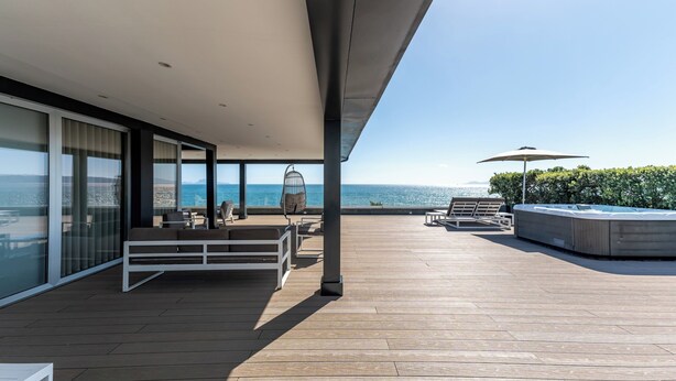 A modern outdoor deck with seating, a hot tub, and a view of the ocean. - Hotel & Resort Tre Fontane Luxury (Portici)