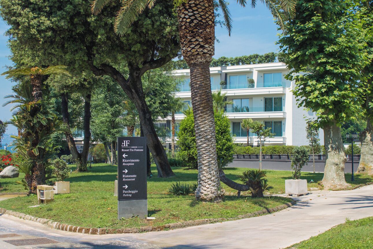 A sign with directions to various hotel amenities including reception, restaurant, parking, and a fountain.