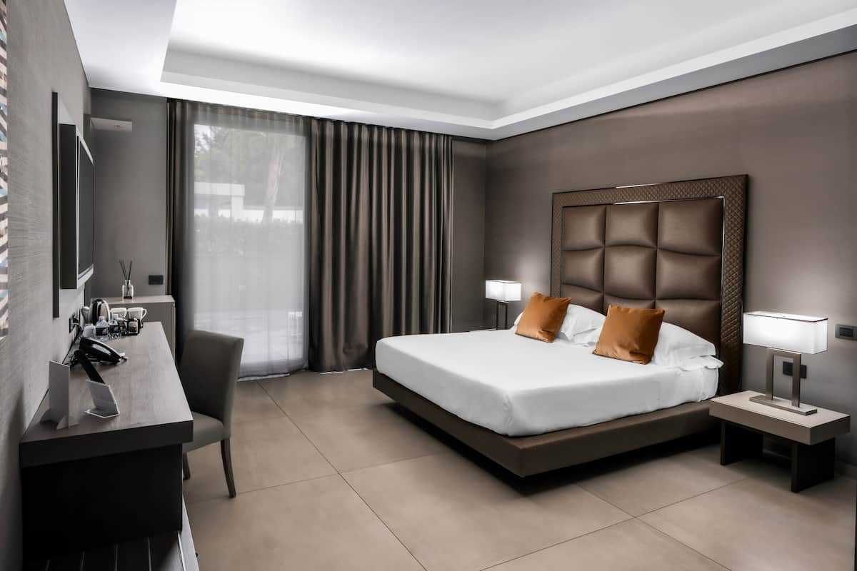 Ein modernes Hotelzimmer mit einem großen Bett, einem Schreibtisch und einem Stuhl.