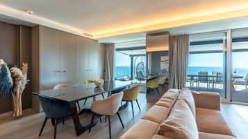 Ein modernes Wohnzimmer mit einem Glastisch, einer Couch und Blick auf den Ozean.