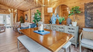 A wooden interior with a dining table, chairs, a chandelier, and decorative items. - BEST LOCATION+ON THE WATER+ROOM FOR EVERYONE! MM23 (Osage Beach)