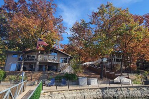 A two-story building with a balcony, a flag, and a stone wall.