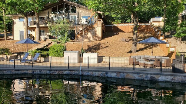 A house with a pool, a bridge, and outdoor furniture. - BEST LOCATION+ON THE WATER+ROOM FOR EVERYONE! MM23 (Osage Beach)
