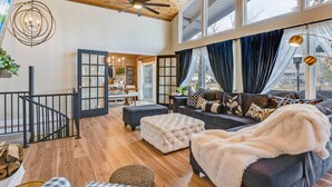 A spacious living area with a high ceiling, a fireplace, and a view of the outdoors. - BEST LOCATION+ON THE WATER+ROOM FOR EVERYONE! MM23 (Osage Beach)