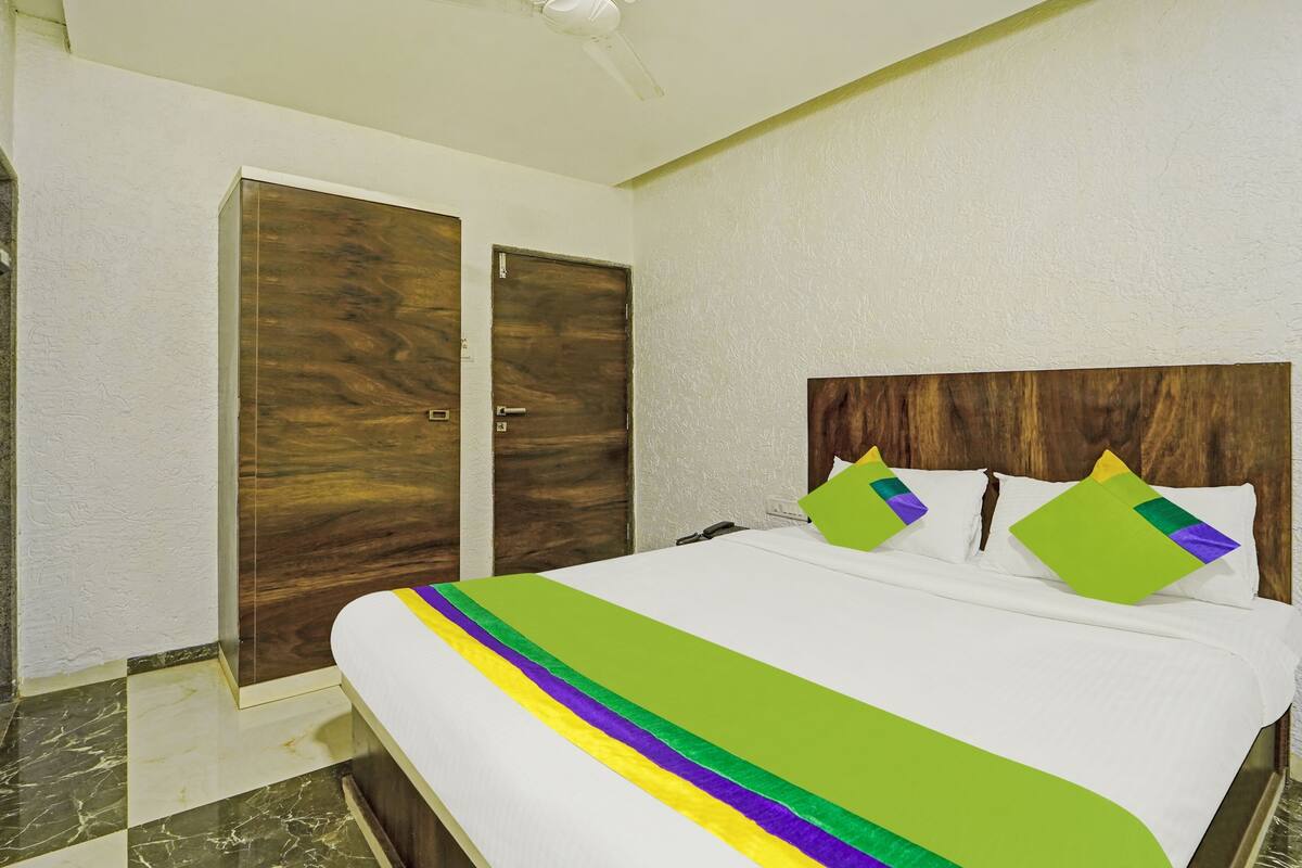 Habitación económica | Escritorio, tabla de planchar con plancha y ropa de cama