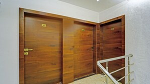 A set of three wooden doors with numbers 403, 402, and 401, and a metal handrail in a hallway. - Treebo Shindola Resort (Mahabaleshwar)