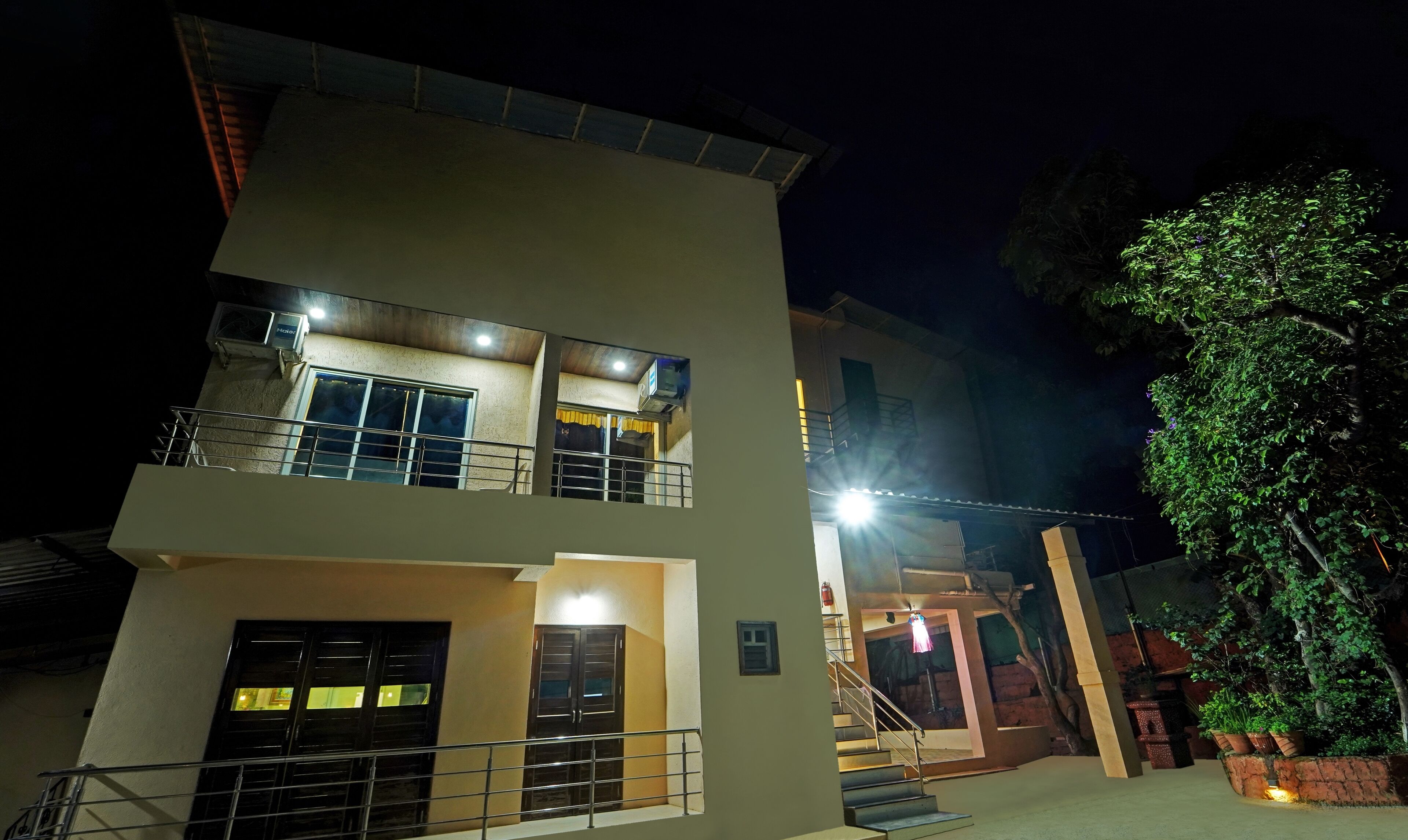 A two-story building with balconies, a staircase, and a well-lit entrance.