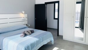 Un dormitorio moderno con cama, mesita de noche y armario.