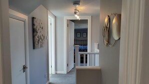 A hallway with a carpeted staircase leading to a second floor. - NEW Fabulous 2BD Maisonette Dunfermline, Fife (Dunfermline)