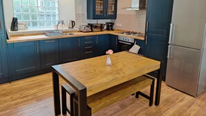 A modern kitchen with dark blue cabinets, a wooden countertop, a stainless steel refrigerator, and a window with frosted glass. - NEW Fabulous 2BD Maisonette Dunfermline, Fife (Dunfermline)