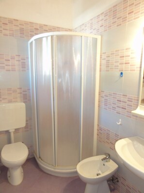 Een douche, een bidet, handdoeken, zeep