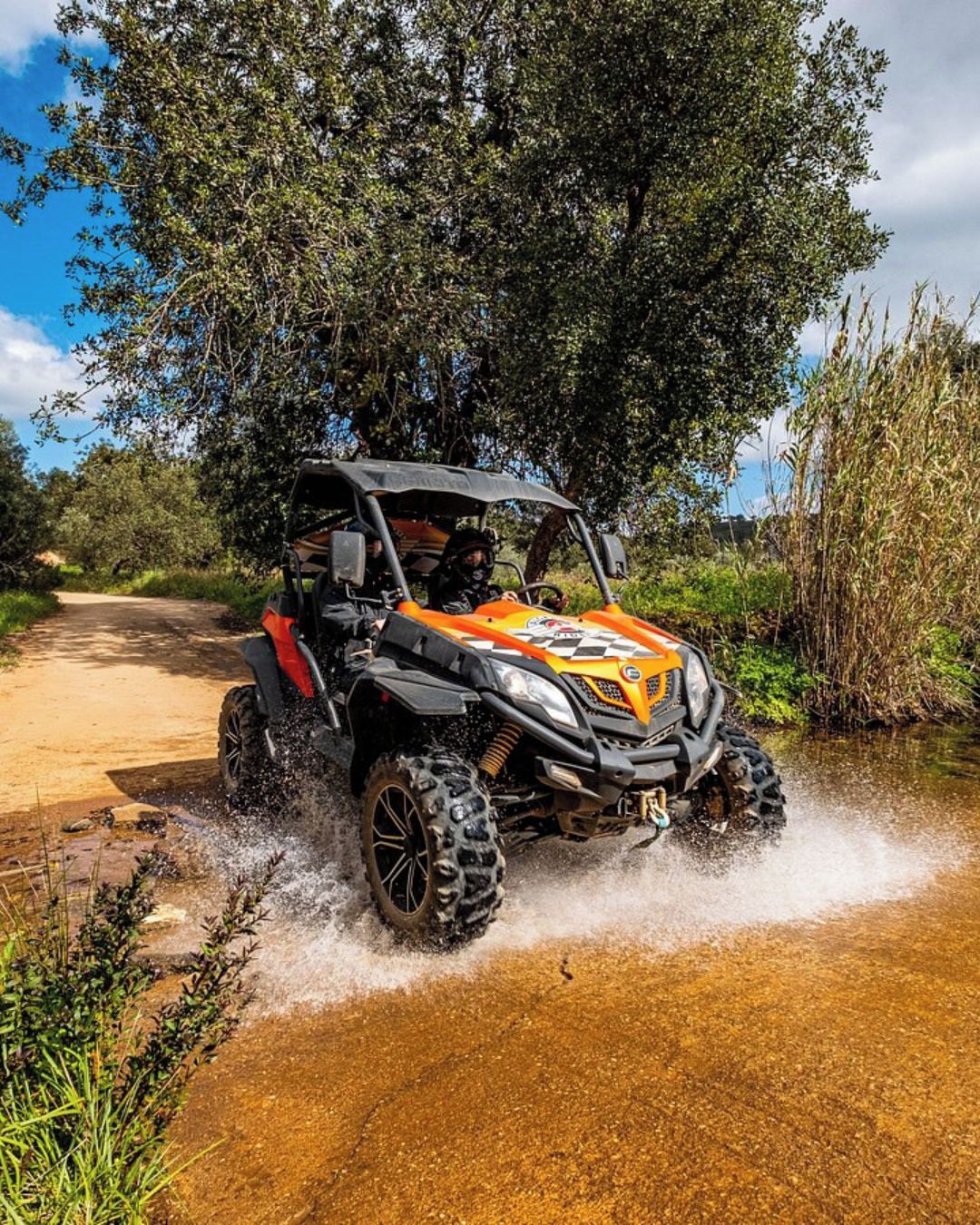 A quad bike crossing a shallow water stream.