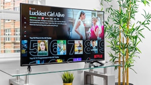Una sala de estar moderna con un televisor de pantalla plana grande mostrando la interfaz de Netflix.