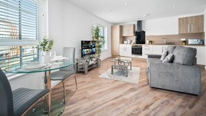 Een modern appartement met een eetgedeelte, woonkamer en keuken.