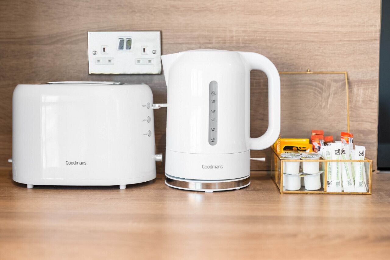 A kitchenette with a toaster, a kettle, and a coffee maker.