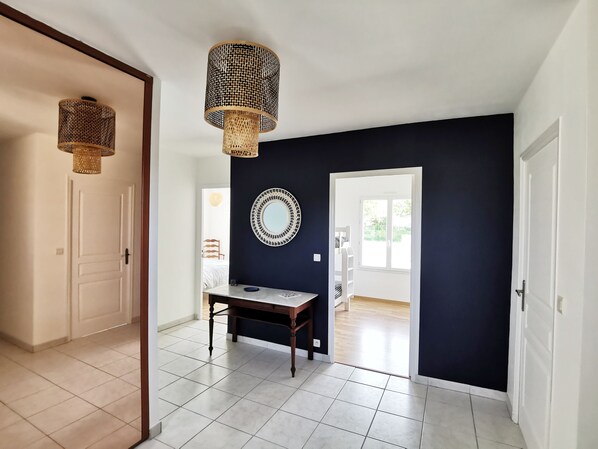 A hallway with a dark wall, a round mirror, and a table with a lamp. - Gîte de Kerninon, bright and spacious single-storey house (Ploulec'h)