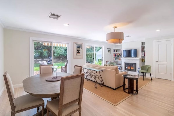 Relax in this stylish living room with a large dining table, comfortable sofa, and fireplace.
