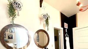 Un baño con dos espejos redondos, un tocador de madera, un lavabo y una planta colgante.