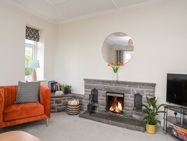 A living room with a fireplace, a sofa, a TV, and a mirror.