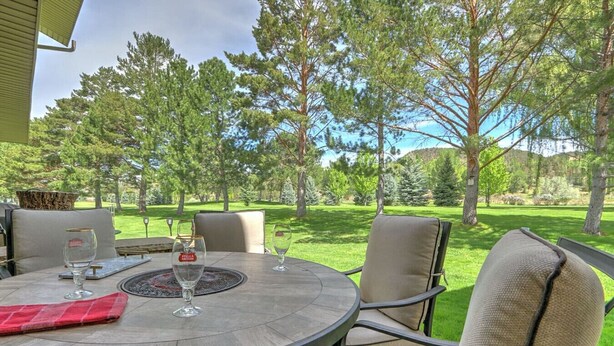 Une terrasse extérieure avec une table ronde, quatre chaises et un verre de Stella Artois.