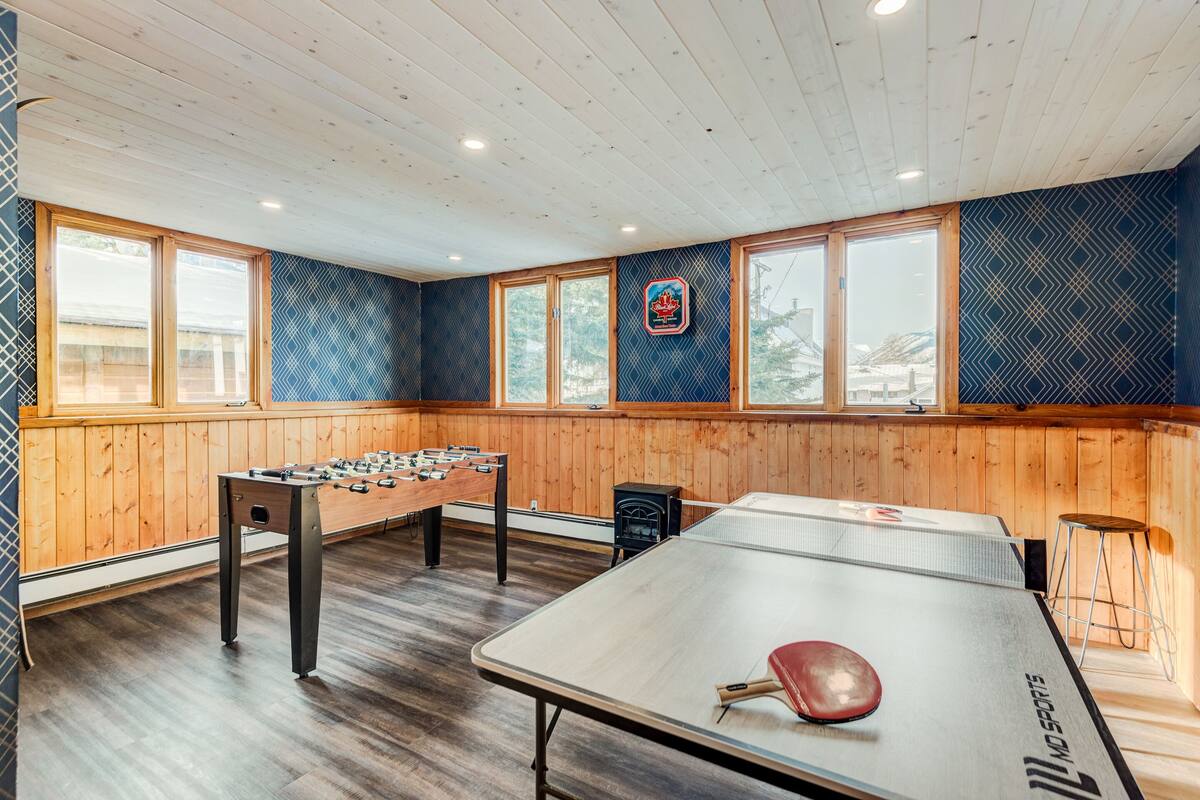 Een kamer met een tafelvoetbaltafel, een pingpongtafel, en een tafelvoetbaltafel met een logo.
