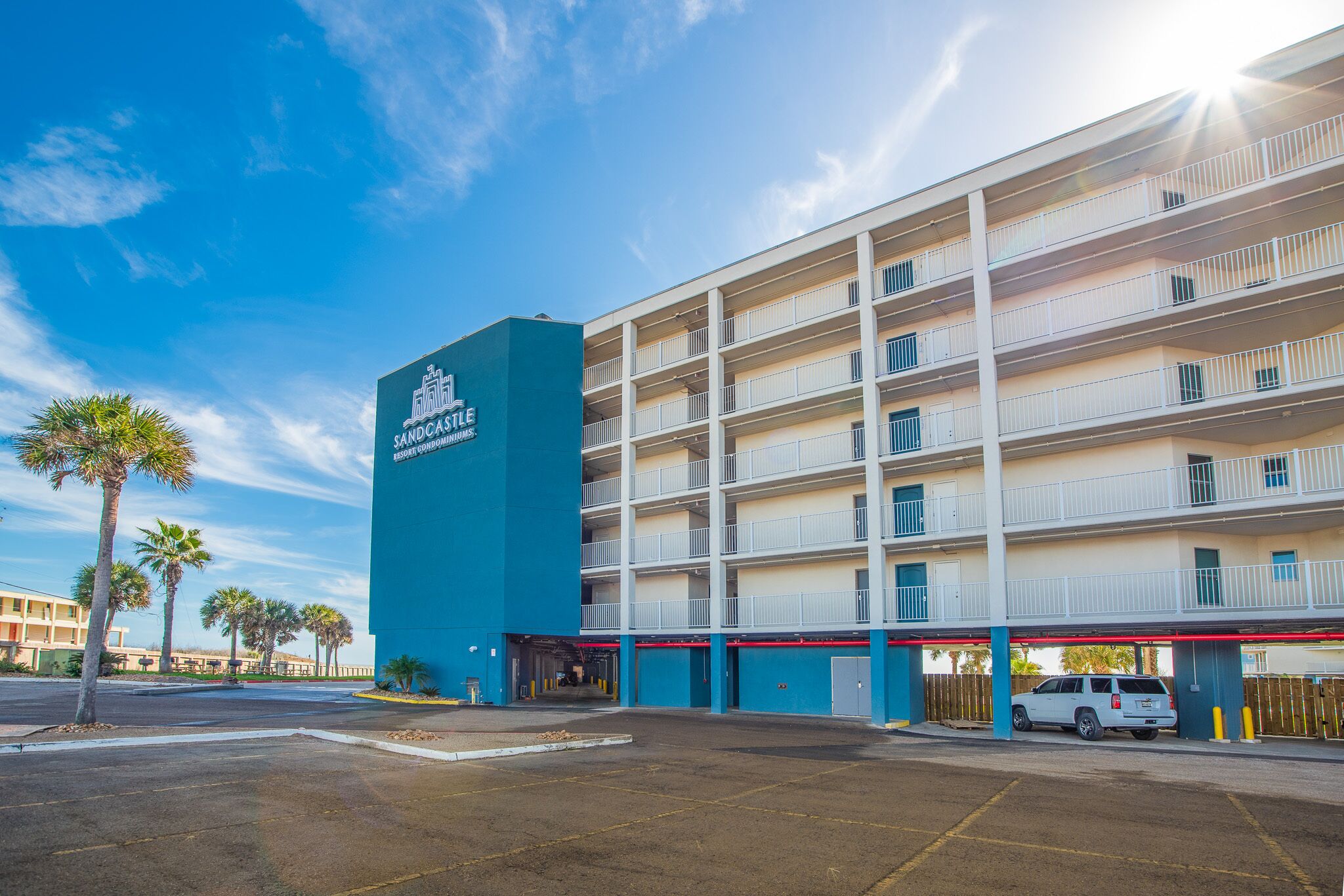 A multi-story hotel with a prominent blue and white facade, featuring balconies on each floor.