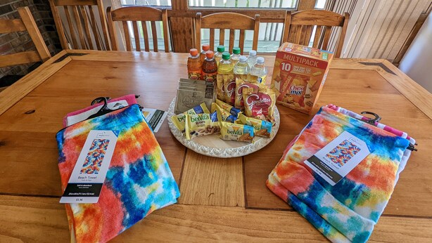 Ein Esstisch mit verschiedenen Snacks, Getränken und einer Packung Beutel.