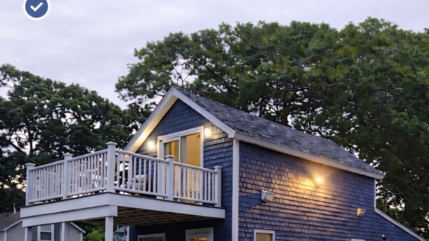 A two-story house with a balcony, a front porch, and a driveway. - The Loft at Oakland Beach 
Ask About Off-season Discounts 
5 min from Airport. (Warwick)