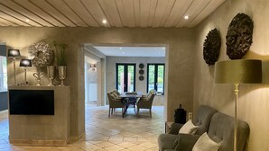 Een ruime woonkamer met een modern design, met een eettafel, banken en een flatscreen-tv.