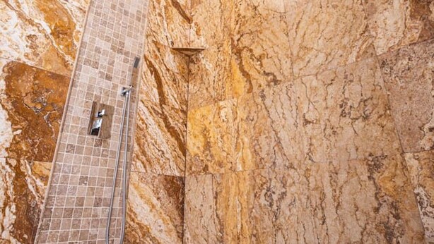 A bathroom with a skylight, marble walls, and a shower area. - Breathtaking 5BR/3BA Villa near Hollywood Beach (Hollywood)
