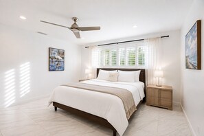 A bedroom with a bed, bedside tables, a ceiling fan, and a window with curtains. - WALK TO BEACH 4BR/2BA VILLA IN HOLLYWOOD LAKES (Hollywood)