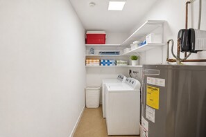 A laundry room with a washing machine, dryer, and stacked laundry baskets. - WALK TO BEACH 4BR/2BA VILLA IN HOLLYWOOD LAKES (Hollywood)