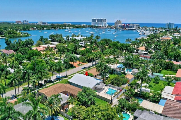 Zona residencial costera con un puerto deportivo, casas y palmeras.